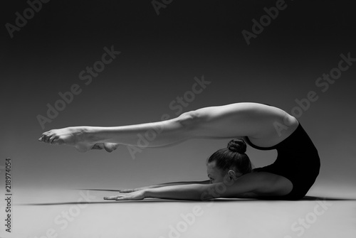 Flexible girl in leotard. Black and white photo.