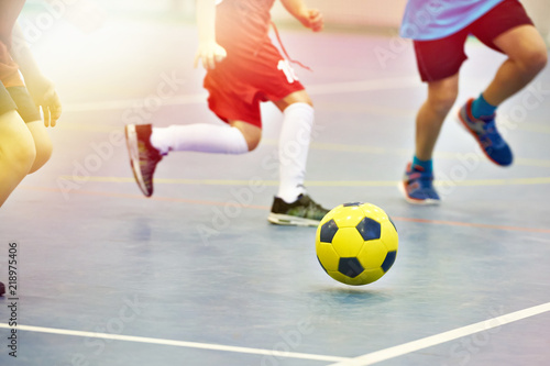 Children playing soccer indoors photo