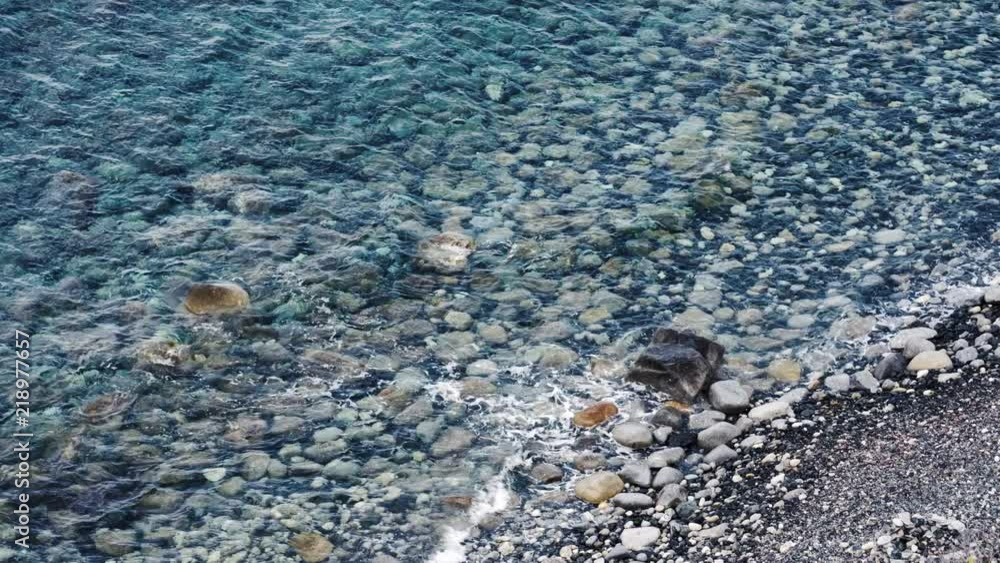 Clear blue sea and waves, with big sea stones and pebble beach. Clear blue sea and waves, with big sea stones and pebble beach.