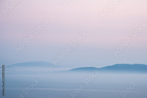 Mountain and sea covered with morning mist before sunrise.