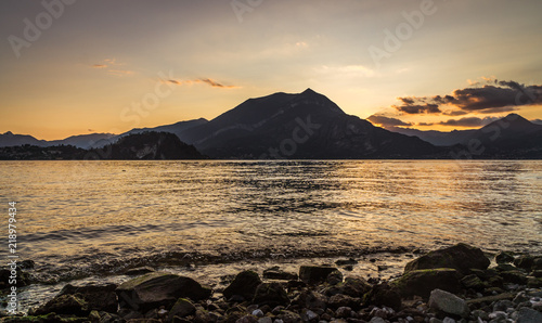 view from beach of mountains andlake at sunset