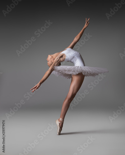 Fototapeta Naklejka Na Ścianę i Meble -  Ballerina in a tutu and pointe shoes makes a beautiful pose