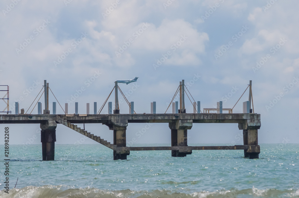 Fototapeta premium the plane is flying over the pier