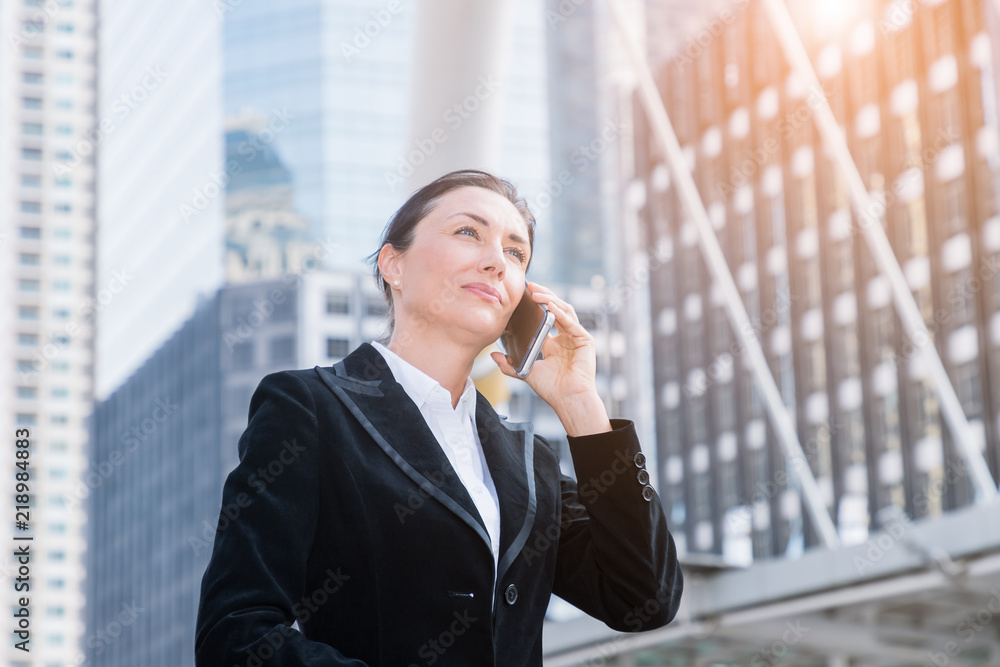 Businesswoman talking on mobile phone in city Businesswoman talking on mobile phone in city