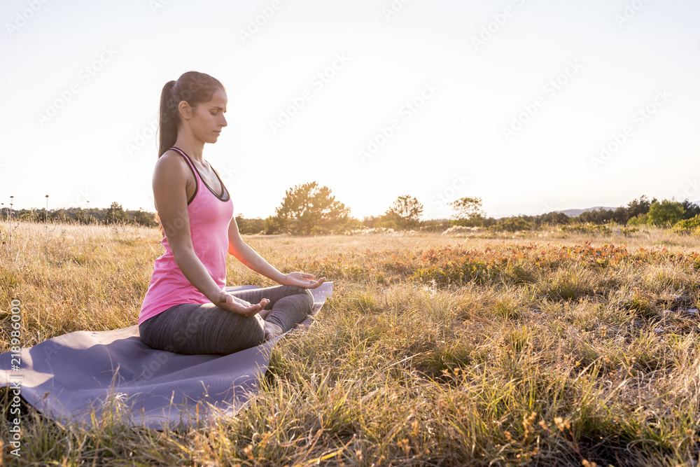 Young beautiful woman practicing Yoga outdoor in nature during sunset Young beautiful woman practicing Yoga outdoor in nature during sunset
