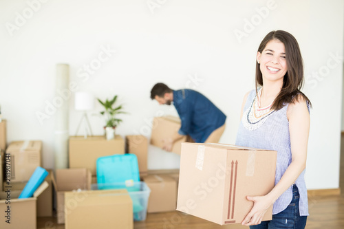 Happy Woman Carrying Box At New Home