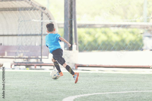 Young Asian football player in blue jersey between competition. © Arnon