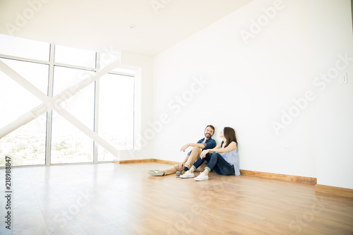 Man Talking With Woman In Empty Room Of New House