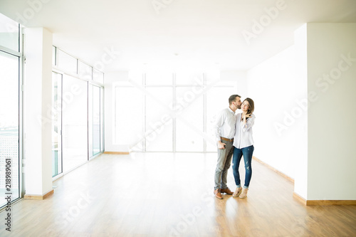 Man Kissing Woman On Cheek In New Apartment