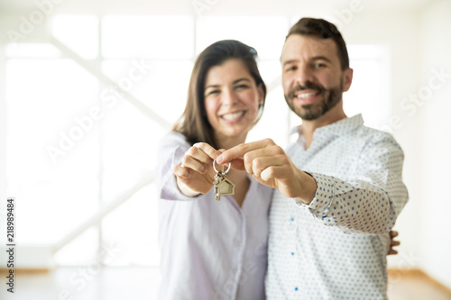 Smiling Owners Showing Keys Of Their New Apartment photo