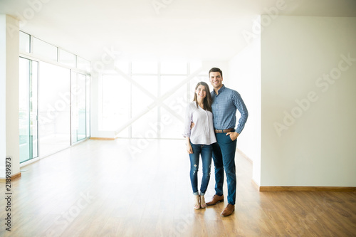 Happy Mid Adult Couple Standing In New Apartment