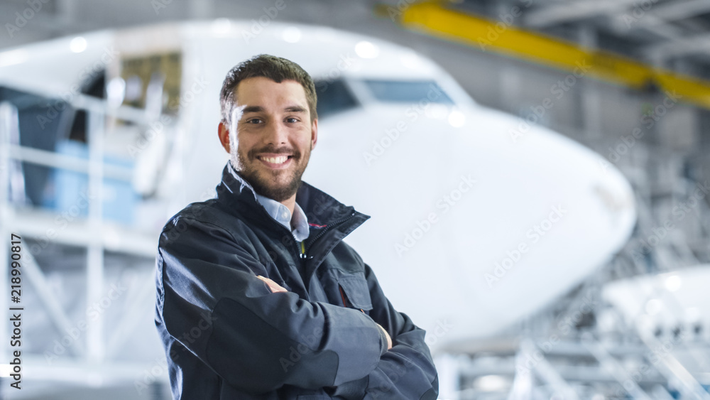 Fototapeta premium Portrait of Aircraft Maintenance Mechanic in Hangar. Airplane on Background.
