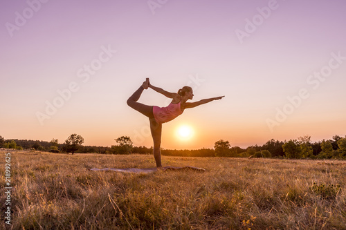 Fototapeta Naklejka Na Ścianę i Meble -  Young beautiful woman practicing Yoga outdoor in nature during sunset
