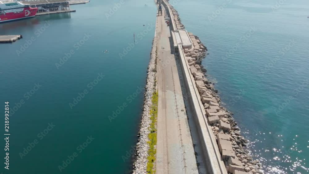 Very long breakwater for docks at Marseilles for cruise boats. Marseille cruise ship port in France with large wall to protect from sea currents. Protected marina in Mediterranean sea. Very long breakwater for docks at Marseilles for cruise boats. Marseille cruise ship port in France with large wall to protect from sea currents. Protected marina in Mediterranean sea.