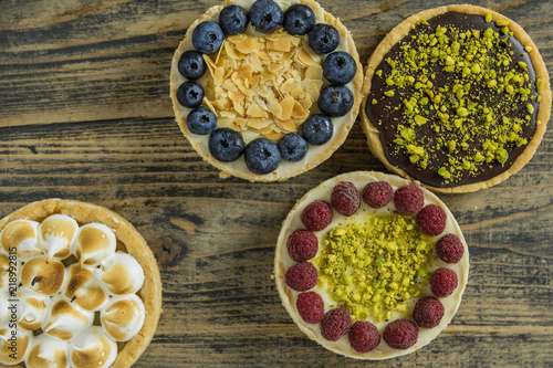 Mini tarts with different filling on rustic wooden black table