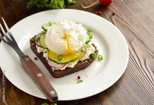 Sandwich with cream cheese, radish, cucumber and poached egg, copy space