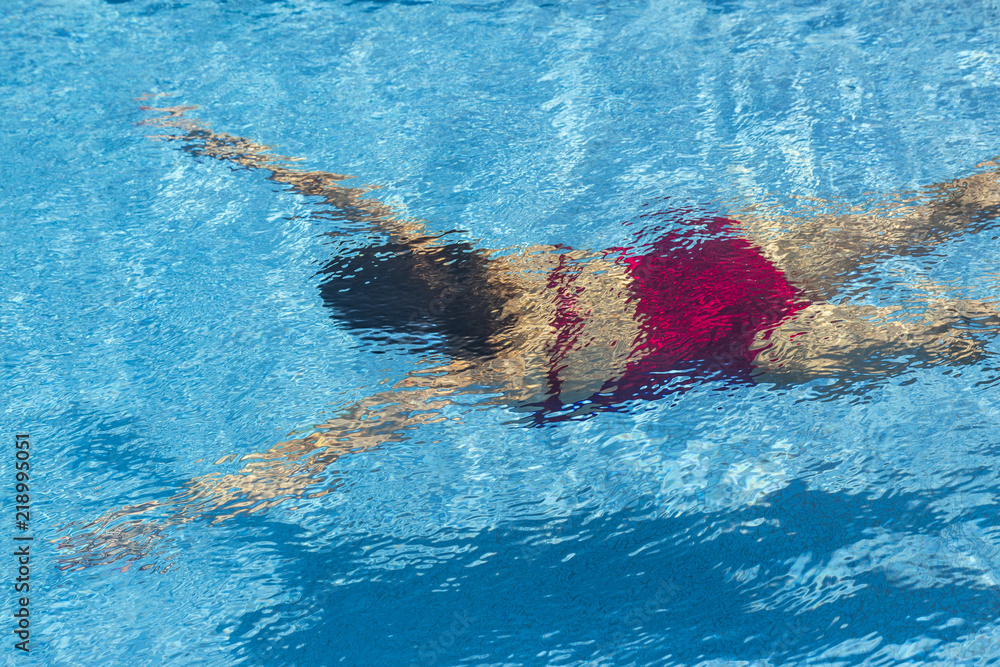 Woman with swimsuit diving in the swimming pool