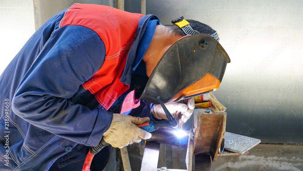 The professional welder works with argon-arc welding. Welds a pipe with a  pipe DN50. Butt weld.. Stock Photo | Adobe Stock