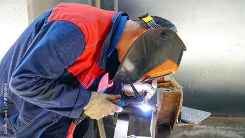 The professional welder works with argon-arc welding. Welds a pipe with a pipe DN50. Butt weld..