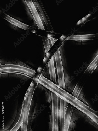 Aerial drone view of multiple roads intersection in city at night. Black and white photo. 
