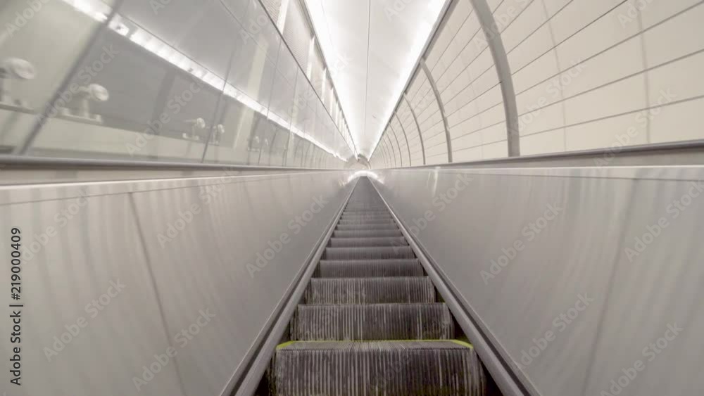 Riding up very long futuristic escalator. At NYV 34th Street�CHudson Yards (IRT Flushing Line) subways station, glass and steel design high escalator going up a long distance. Riding up very long futuristic escalator. At NYV 34th Street�CHudson Yards (IRT Flushing Line) subways station, glass and steel design high escalator going up a long distance.