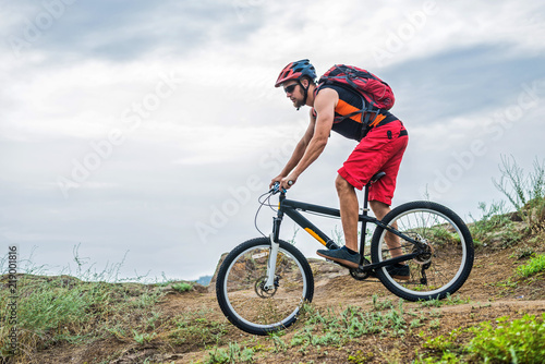 Cyclist on a mountain bike riding on the rock, free space for your text.
