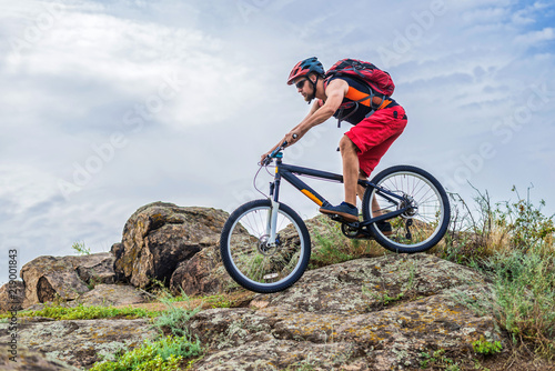 Concept of extreme cycling, a biker on a mountain bike on the blue sky background, free space.