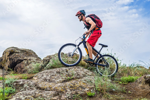 Cyclist descending down the rock on a mountain bike  an active lifestyle.