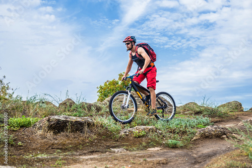 Cyclist on a mountain bike riding on the rock, free space for your text.