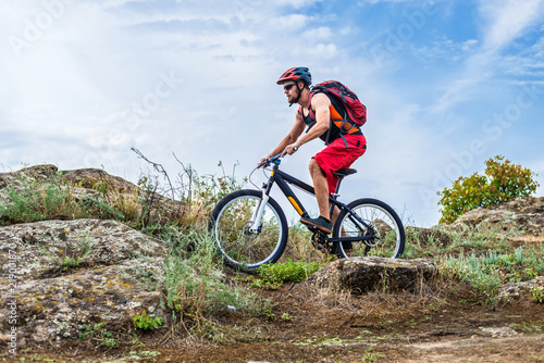 Cyclist riding down the rock on a mountain bike, extreme enduro cycling. © mihakonceptcorn