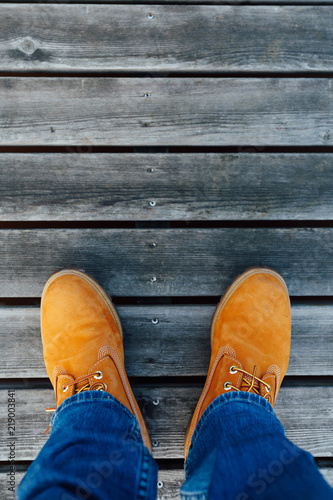 yellow winter boots on wooden planks background © nikkytok