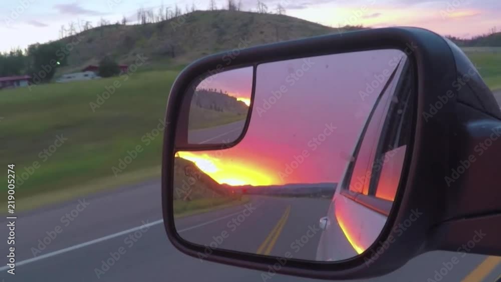 A medium shot on a rear view mirror of a sunset. shot is taken on 60 fps and edited in 30 fps. A medium shot on a rear view mirror of a sunset. shot is taken on 60 fps and edited in 30 fps.