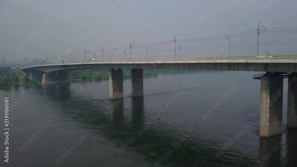 Aerial under the bridge over the river Yenisei Krasnoyasrk city drone footage Aerial under the bridge over the river Yenisei Krasnoyasrk city drone footage