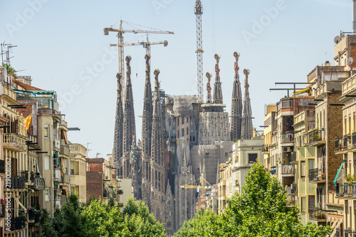 Barcelona, Spain  July, 2017: Cathedral of La Sagrada Familia from the Hospital of Sant Pau. It is designed by architect Antonio Gaudi and is being build since 1882.