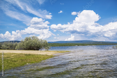 Fototapeta Naklejka Na Ścianę i Meble -  Shore of the river similar to the beach, with a blue sky with clouds, beautiful.