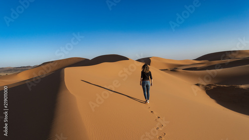 Chica Caminando por dunas del desierto
