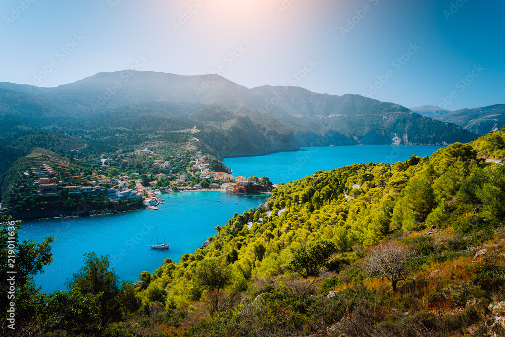 Panoramic view to Assos village Kefalonia. Greece. Beautiful turquoise colored bay lagoon water surrounded by pine and cypress trees along the coastline
