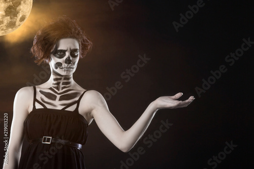 Halloween. Portrait of young beautiful girl with make-up skeleton on her face