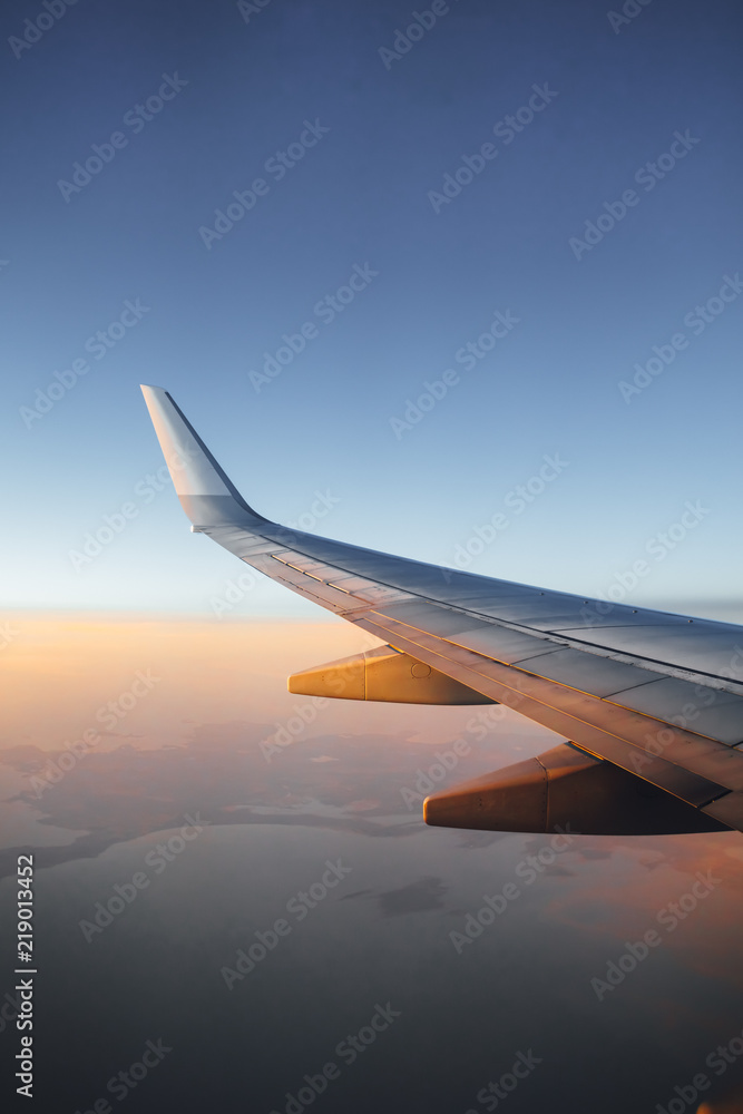 Obraz premium airplane wing against sunset sky background