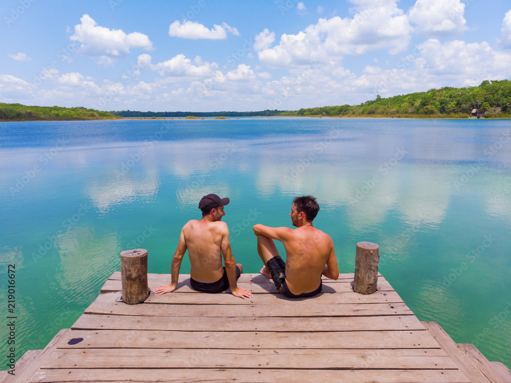 Two friends sitting by a freshwater lagoon, Mexico