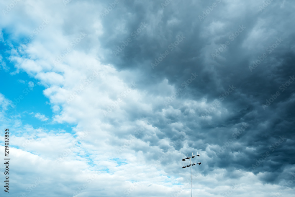 Dark ominous clouds over stadium reflector lights