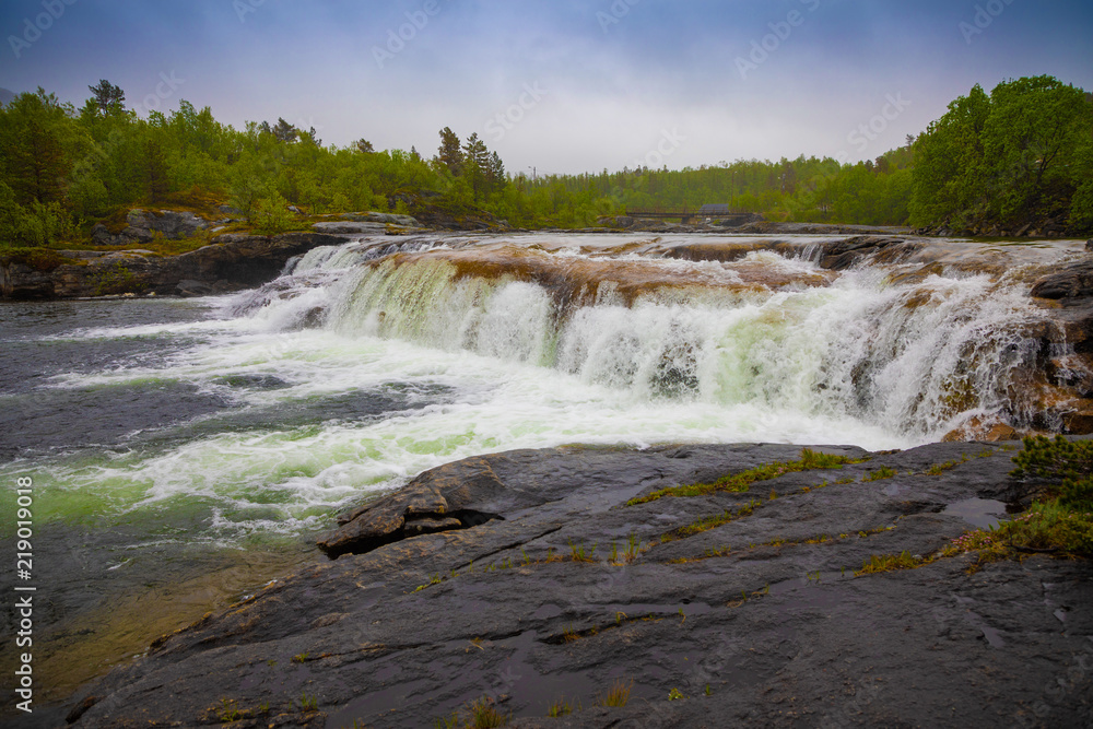 Small waterfall next to Valnesforsen fall in rainny day in Norway Small waterfall next to Valnesforsen fall in rainny day in Norway