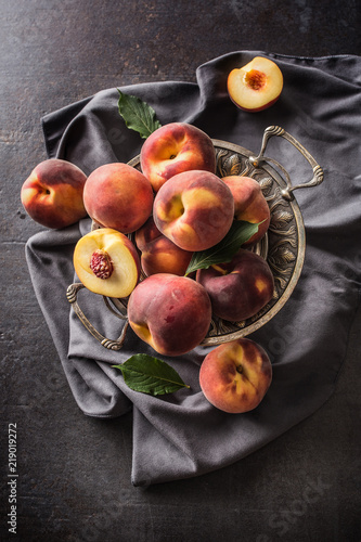 A group a ripe peaches in rustic bowl