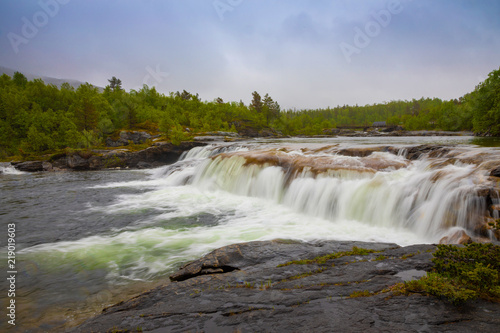 Small waterfall next to Valnesforsen fall in rainny day in Norway