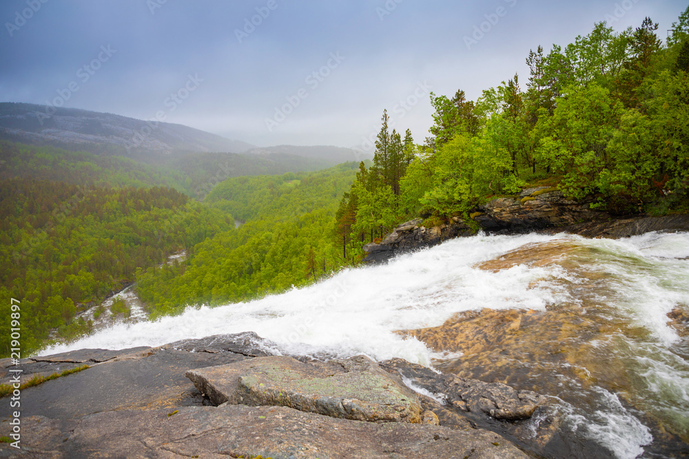 View of green mountain from Valnesforsen waterfall in Norway View of green mountain from Valnesforsen waterfall in Norway