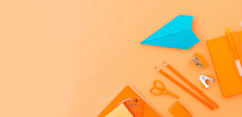 Back to school styled border with school supplies and paper blue plane orange background banner