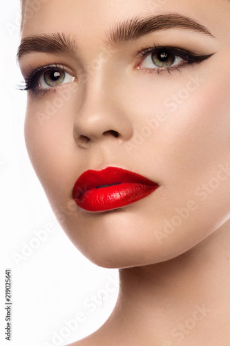 Close up portrait of beautiful young model with professional makeup  perfect skin. Trendy eyelines and red lips. Shiny eyelines