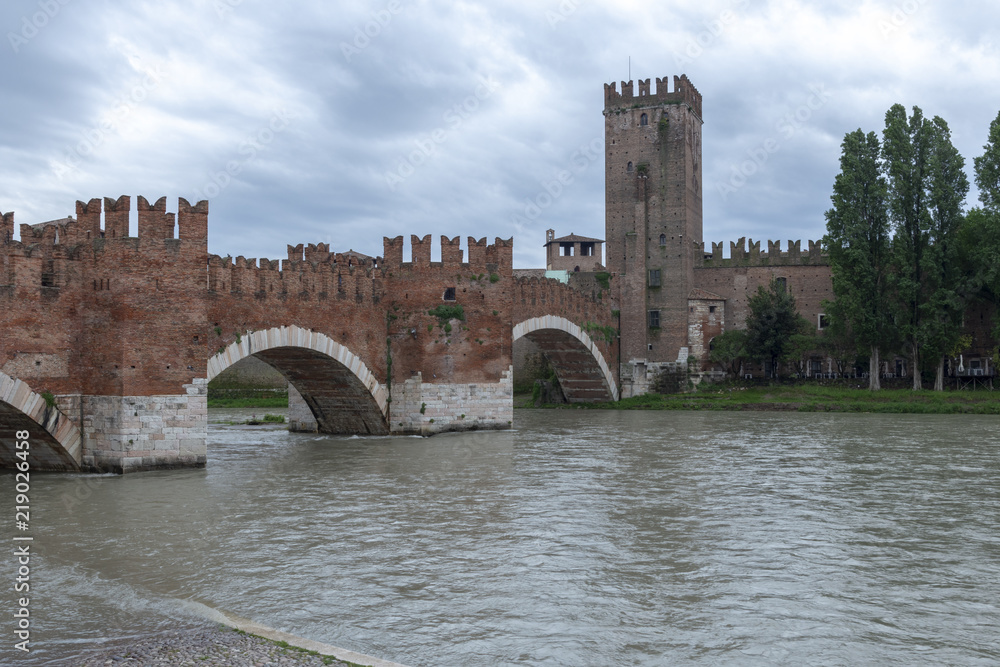 Castelvecchio bridge with castle tower against cloudy sky