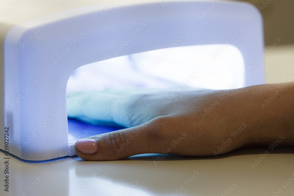 Fototapeta premium Woman hand in uv led lamp drying gel manicure