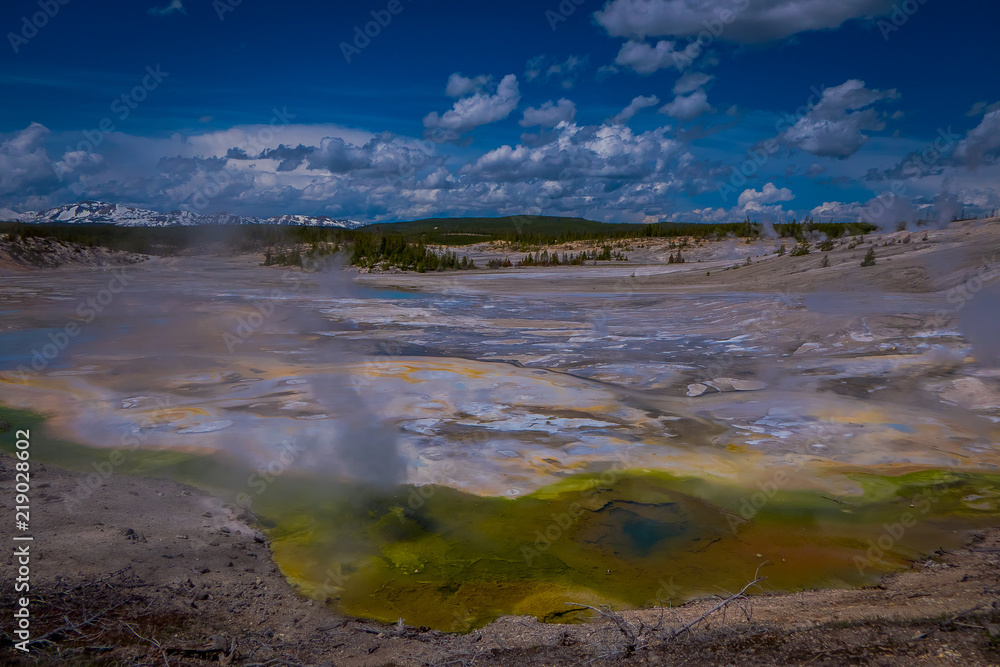 Steaming opaque thermal pools at Norris Geyser Basin. Yellowstone National Park, Wyoming, in beautiful blue sky and sunny day Steaming opaque thermal pools at Norris Geyser Basin. Yellowstone National Park, Wyoming, in beautiful blue sky and sunny day